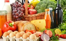 Groceries in wicker basket including vegetables and fruits